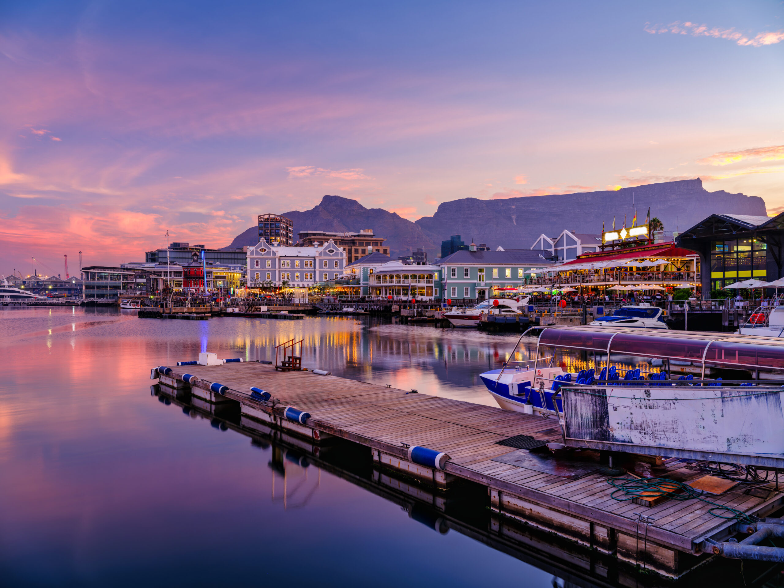 Victoria And Alfred, V And A Waterfront Lit Up During A Colorful Sunset With Table Mountain In The Background, Cape Town, South Africa