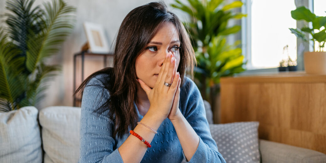 Sad Young Pregnant Woman Sitting On The Sofa At Home