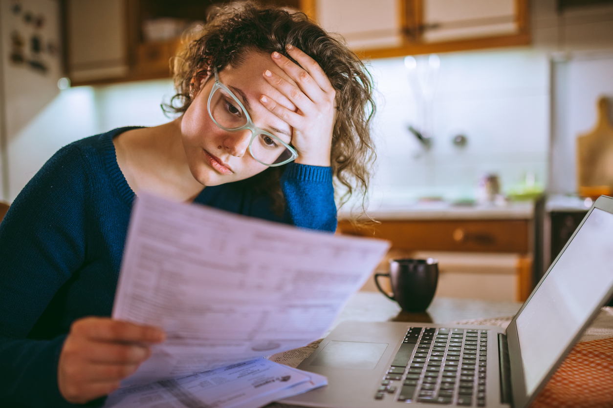 Woman Going Through Bills, Looking Worried